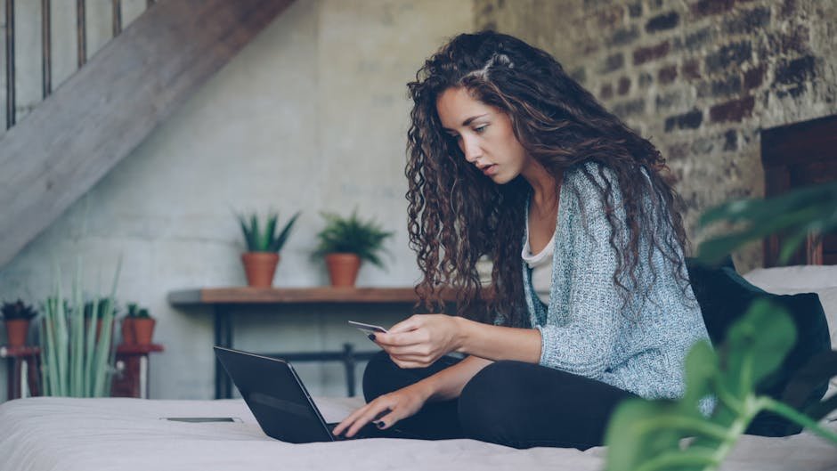 Young woman using laptop and credit card for online shopping at home.