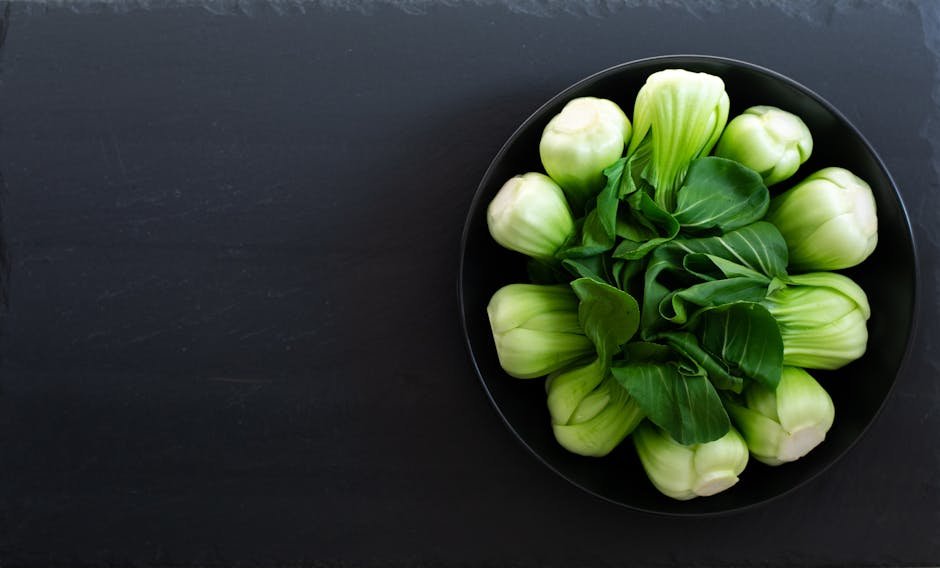 Top view of fresh bok choy arranged in a bowl on a slate background, perfect for healthy eating concepts.