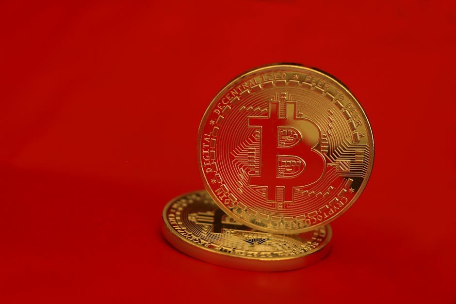 Close-up of golden Bitcoin coins with a red background, symbolizing digital currency and blockchain technology.