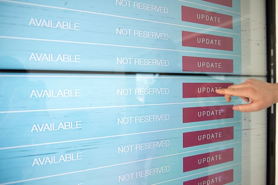 A hand interacts with a digital touchscreen interface showing availability and update options.