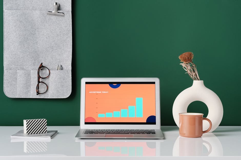 Trendy office desk setup featuring a laptop, stylish decor, and modern elements.