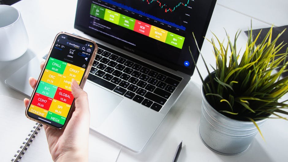 Person analyzing stock market trends on smartphone and laptop.
