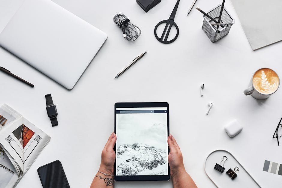 Flat lay of a modern workspace featuring a tablet, gadgets, and coffee for creative work.